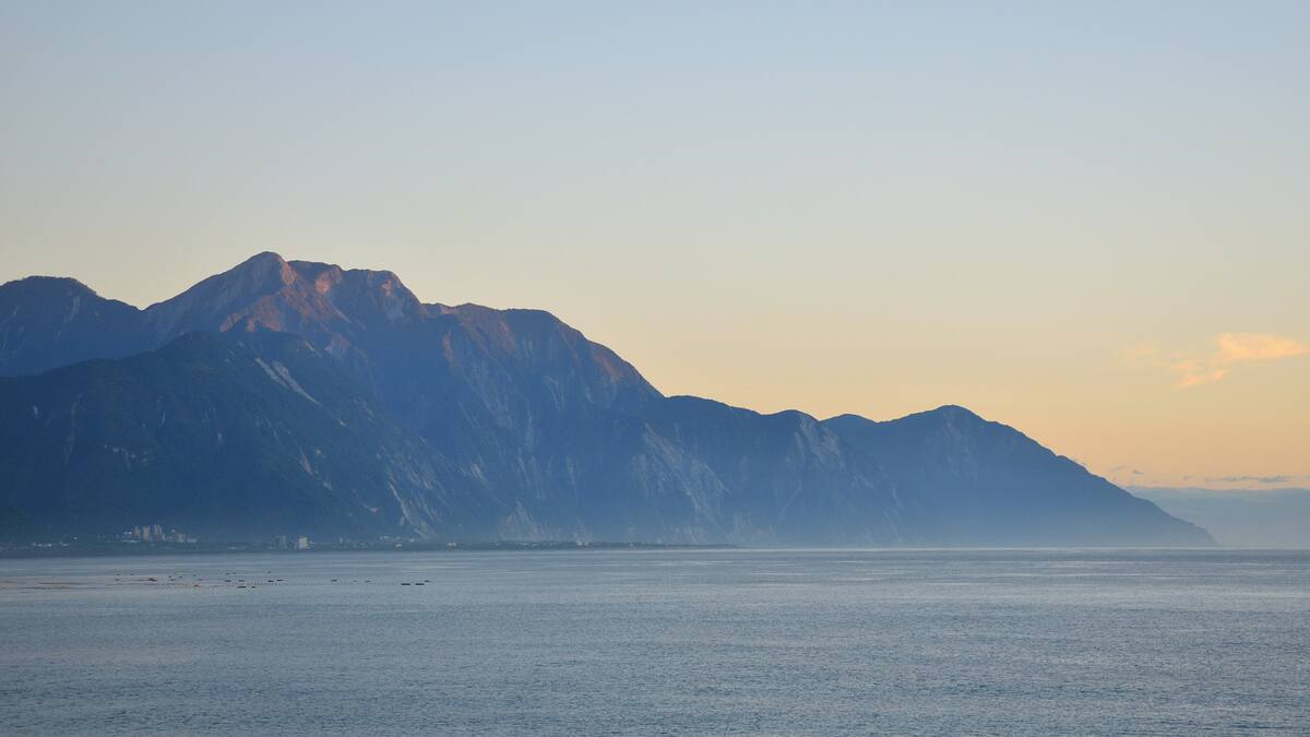 黃昏的海岸與遠山（示意配圖）